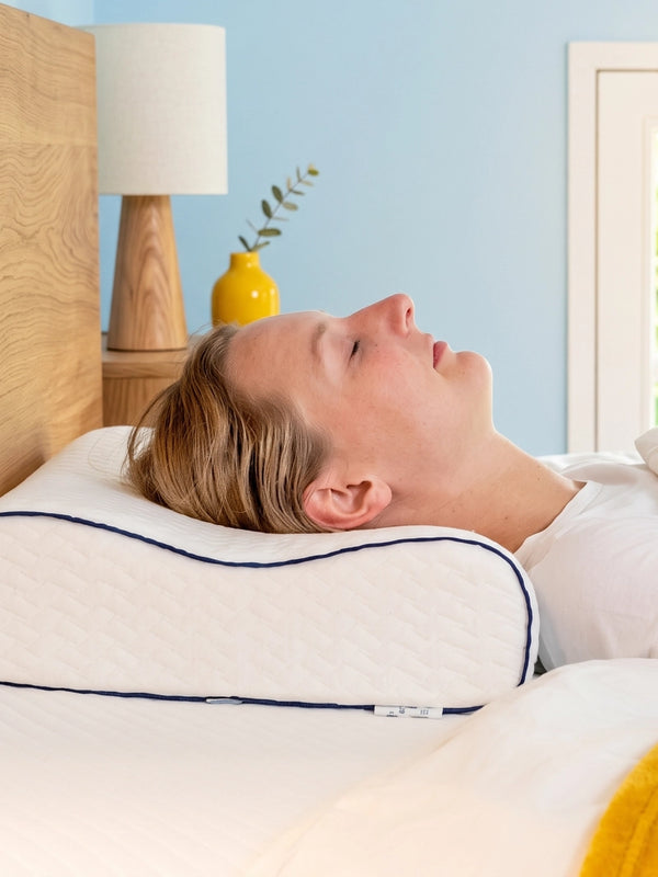 Vrouw slaapt op haar rug op een ergonomisch Ella hoofdkussen.