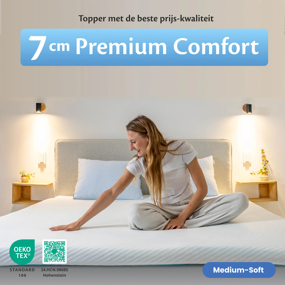 De Ella Matrastopper 7 cm op een opgemaakt bed, met een vrouw die de zachte toplaag voelt