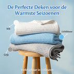 Ella Koeldekens in drie kleuren — wit, lichtblauw en grijs — gevouwen op een houten krukje, ideaal als zomerdeken voor de warmste seizoenen