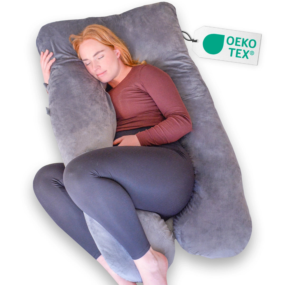 Een vrouw ontspant op een groot grijs zwangerschapskussen van Ella Sleeps U - Shape Minky, perfect voor extra steun.