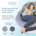 Vrouw ontspant op de bank met een open boek, ondersteund door een Ella Sleeps zwangerschapskussen.