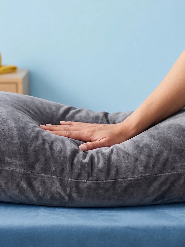 Grijs Ella zwangerschapskussen op een blauw opgemaakt bed.