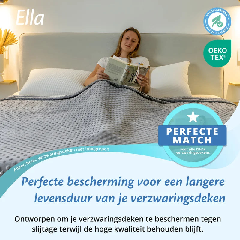 Vrouw leest in bed onder een grijze Ella hoes voor verzwaringsdeken, met OEKO TEX en hypoallergeen icoon.